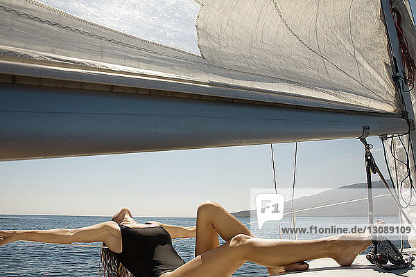 Woman sunbathing on yacht sailing in sea