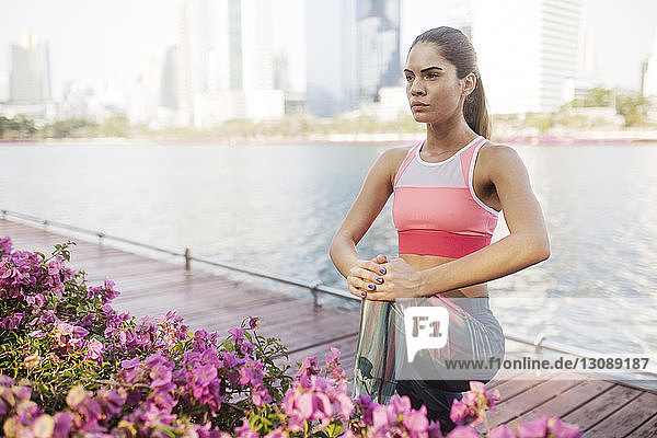 Woman exercising and stretching by plants at park