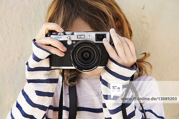 Close-up of boy photographing with camera