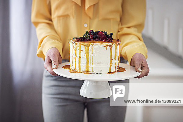 Mitschnitt einer Frau  die zu Hause einen Kuchen in der Hand hält
