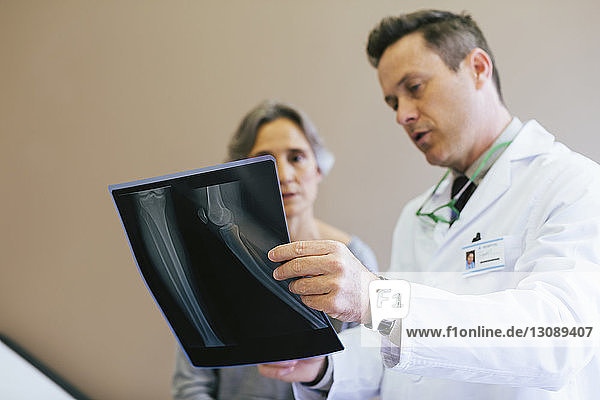 Close-up of doctor and patient looking at x-ray image in medical clinic
