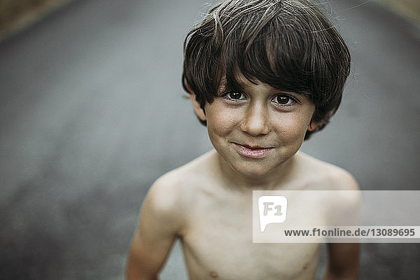 Hochwinkelporträt eines Jungen ohne Hemd auf der Landstraße
