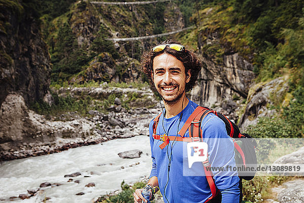 Portrait of smiling male hiker standing by river at Sagarmatha National Park
