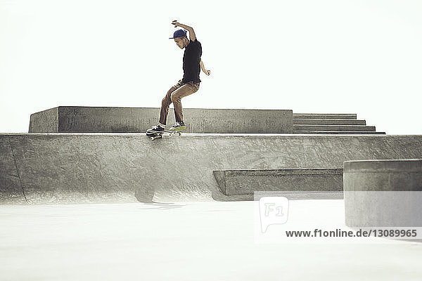 Junger Mann macht Stunts auf dem Skateboard