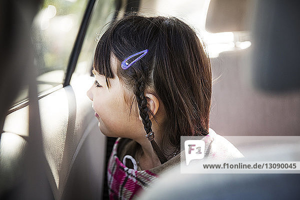 Mädchen schaut weg  während sie im Auto sitzt