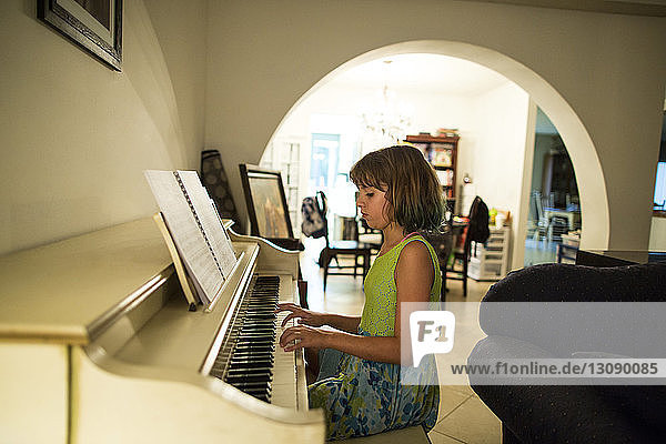 Seitenansicht eines zu Hause Klavier spielenden Mädchens