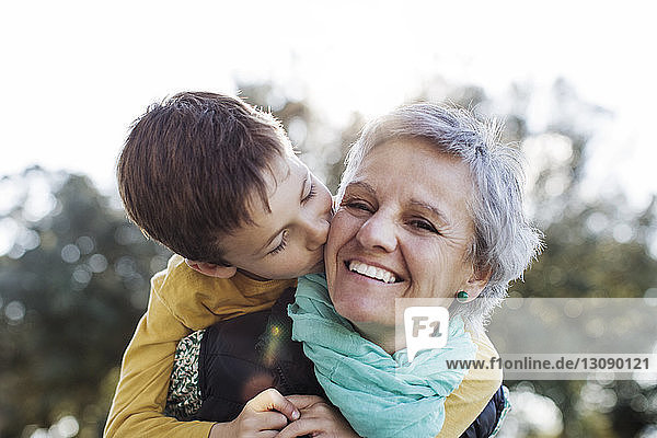 Liebender Enkel küsst Großmutter im Park