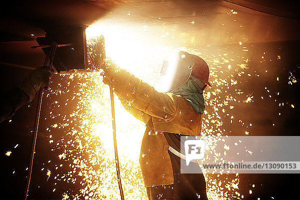 Seitenansicht eines Arbeiters beim Schweißen eines Flugzeugflügels in der Industrie