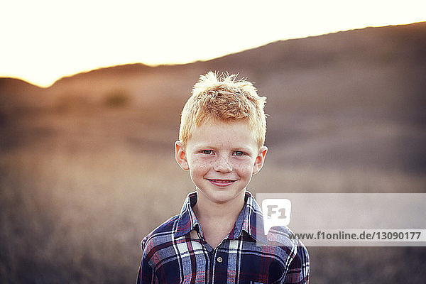 Portrait of smiling boy at field on sunny day