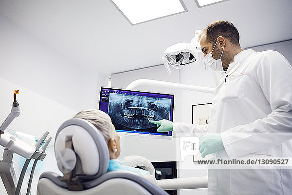 Zahnarzt erklärt der Patientin in der Klinik das Röntgenbild
