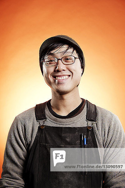 Porträt eines lächelnden Mannes vor orangem Hintergrund