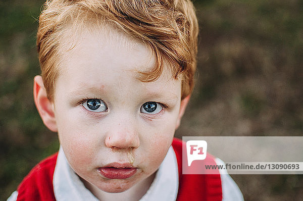 Close-up portrait of sad baby boy standing on field