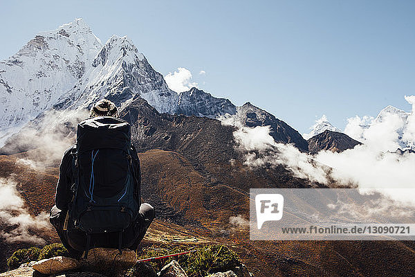 Rückansicht eines Wanderers mit Rucksack am bergblauen Himmel im Sagarmatha-Nationalpark