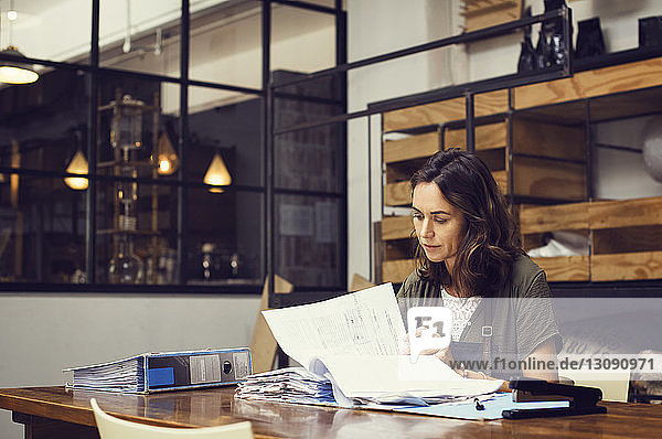 Reife Besitzerin analysiert Dokumente im Café