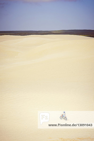 Jugendliches Mädchen fährt Fahrrad in der Wüste