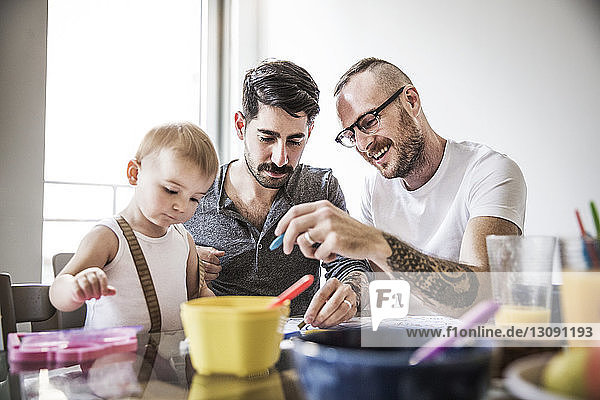 Väter malen mit der Tochter am Frühstückstisch