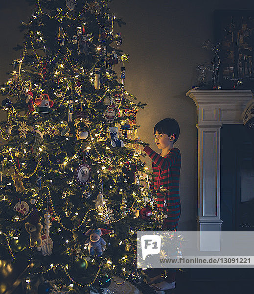 Junge schaut auf beleuchteten Weihnachtsbaum