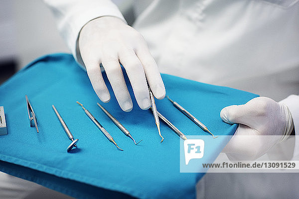 Mittelteil eines Zahnarztes mit verschiedenen zahnärztlichen Geräten auf einem Tablett