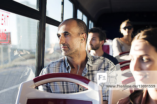 Passengers looking through window while traveling in bus
