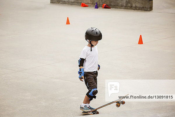 Junge steht mit Skateboard auf Rampe