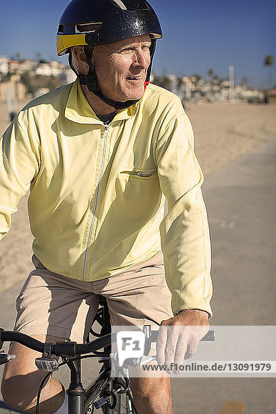Man looking away while riding bicycle on road