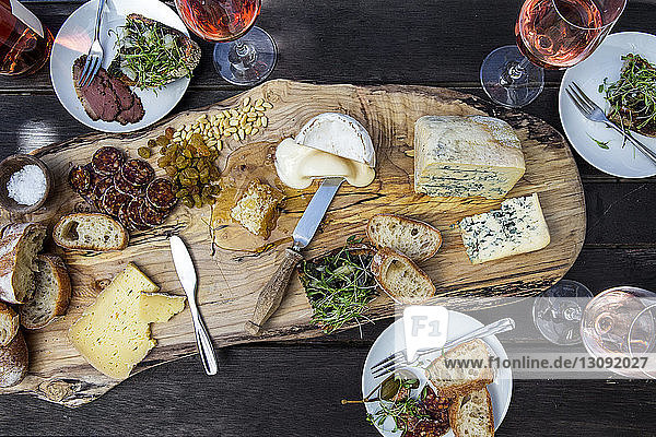 Hochwinkelansicht von verschiedenen Speisen mit Wein  die auf einem Holztisch serviert werden