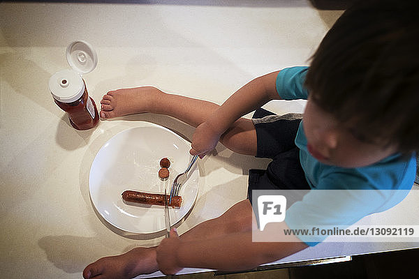Boy eating sausage
