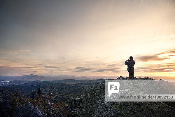 Woman standing on mountain during sunset