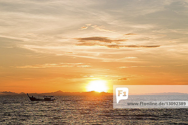 Silhouettenboot auf dem Meer gegen den Himmel bei Sonnenuntergang