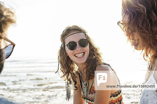 Freunde geniessen am Strand bei klarem Himmel am sonnigen Tag