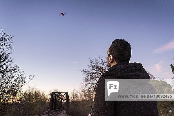 Mann Fliegende Drohne gegen den Himmel bei Sonnenuntergang