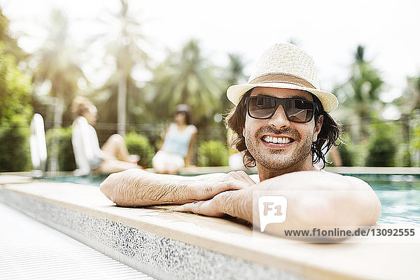 Glücklicher Mann entspannt sich im Schwimmbad eines Touristenortes