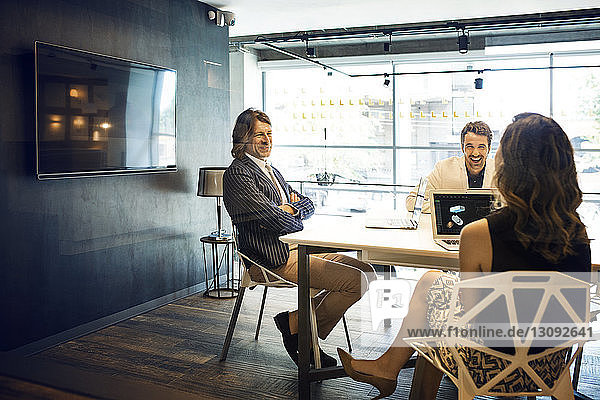Geschäftsleute lächeln während einer Besprechung im Büro