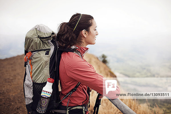 Thoughtful female hiker carrying backpack while standing