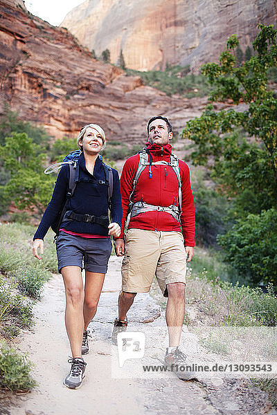 Hikers walking on footpath against mountain