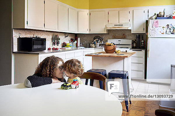 Mother playing with son in kitchen at home