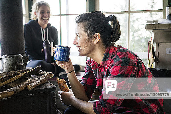 Frauen lachen beim Trinken in der Hütte