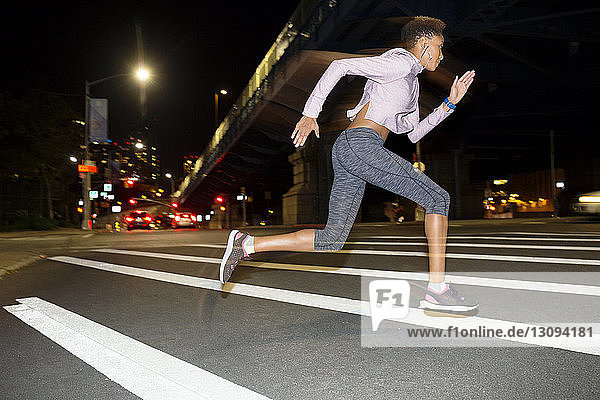 Weibliche Athletin läuft nachts auf der Straße