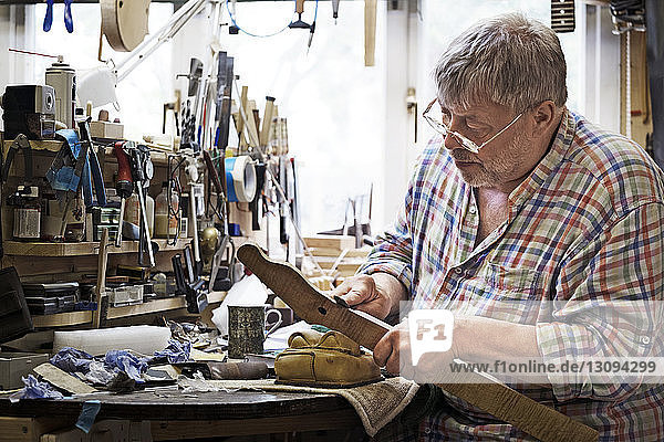 Craftsman shaping fretboard in workshop