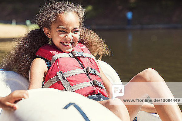 Glückliches Mädchen sitzt an einem sonnigen Tag im Tretboot