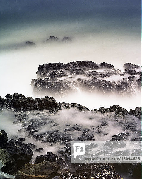High angle view of rocks in sea during foggy weather