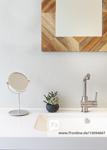 Spiegel über Waschbecken gegen weiße Wand