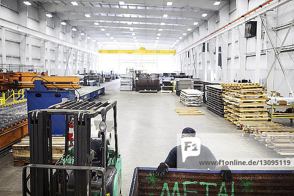 Schrägaufnahme eines Arbeiters in einer Fabrik der Stahlindustrie