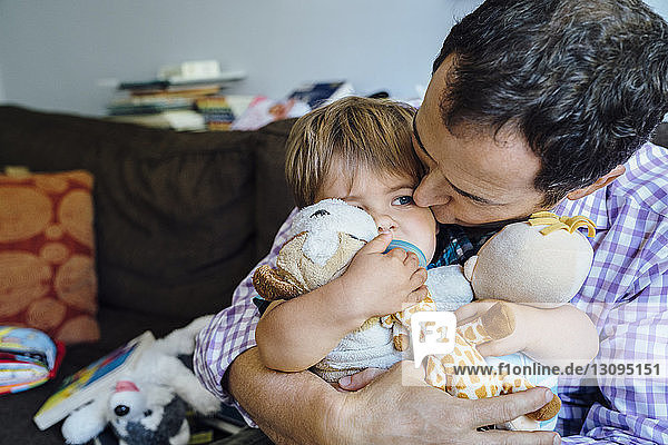 Nahaufnahme eines Vaters  der seinen Sohn zu Hause auf dem Sofa küsst