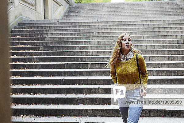Junge Frau geht gegen Stufen im Park
