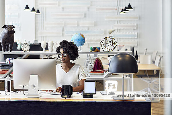 Geschäftsfrau  die im Büro am Desktop-Computer arbeitet