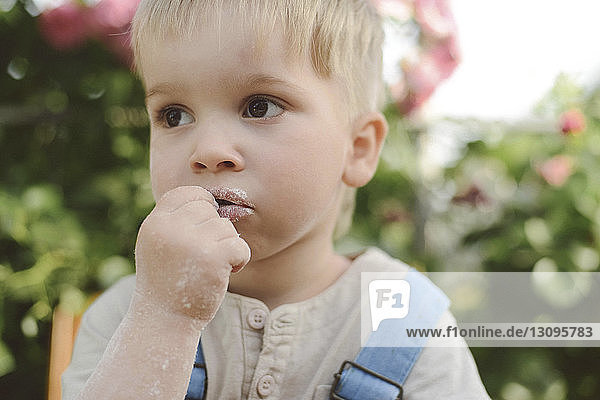 Close-up of thoughtful boy looking away in yard