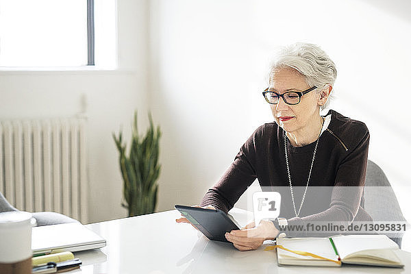 Businesswoman using digital tablet on table in creative office