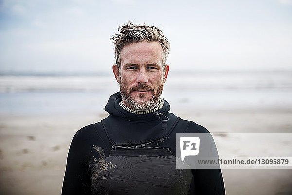 Porträt eines selbstbewussten Surfers am Strand stehend