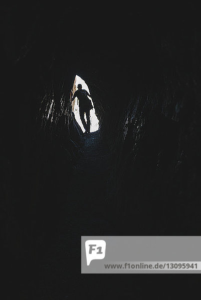 Low angle view of silhouette hiker standing in cave at Pisac